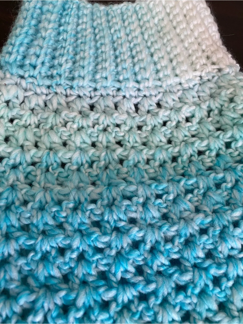 Hand-crocheted light blue dog sweater with buttons.
